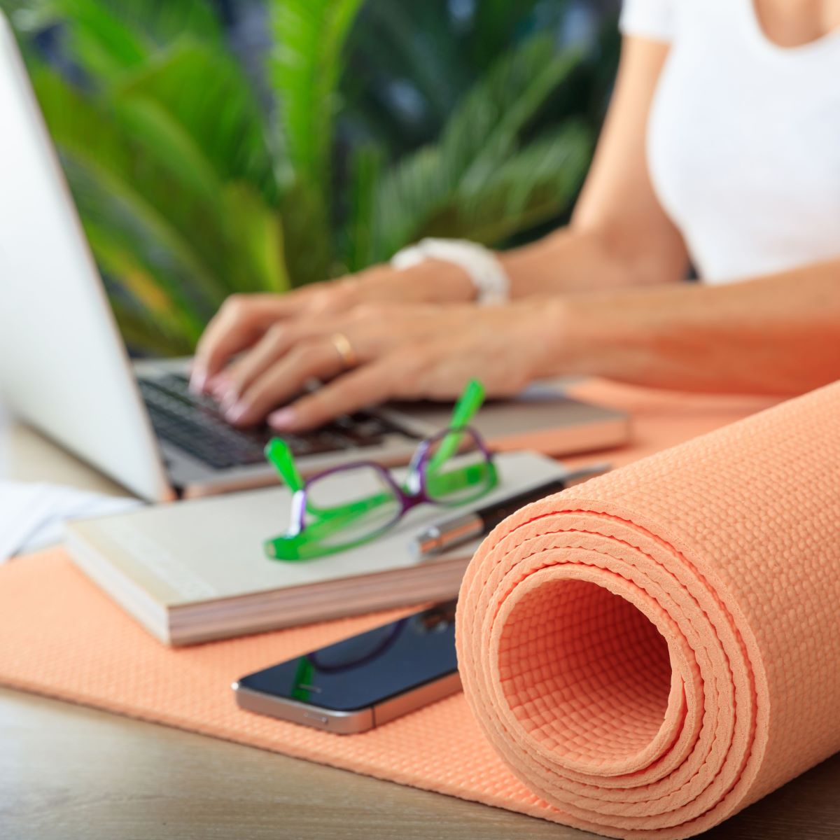 Employee working next to yoga mat, signifying Houston corporate wellness program