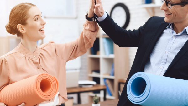 Coworkers high five leading up to a personalized corporate fitness activity as a part of a Houston corporate wellness program.